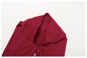 Macro detail of high-waist burgundy yoga pants showing flatlock seams and soft fabric