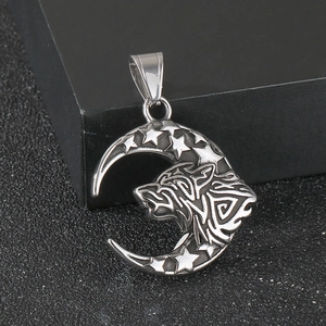 Detailed macro shot of a silver wolf head and crescent moon pendant with star engravings