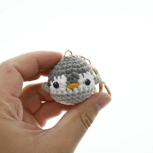 Handmade crochet penguin keychain in grey and white yarn with metal ring