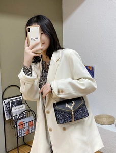 Close-up of black sequined crossbody bag featuring golden deer buckle and chain strap