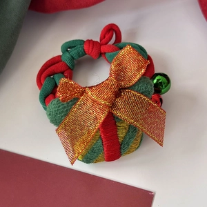 Détail d'un chouchou de Noël fait main avec clochette en couleurs rouge et verte