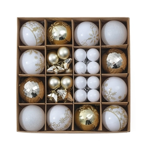 Detailed view of gold and white Christmas ornaments set in a grid packaging box