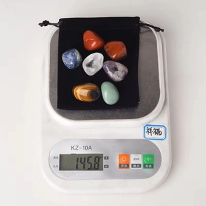 Weight measurement of seven polished healing crystal stones and a black drawstring pouch