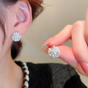Detail of cluster stud earrings featuring white mini pearls and 14k gold plating