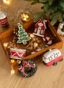 Detail of assorted resin Christmas ornaments including trees and candy sticks on wooden tray