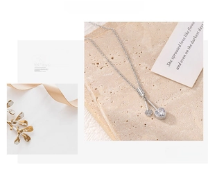 Macro detail of silver heart and arrow pendant with sparkling heart-shaped zircon