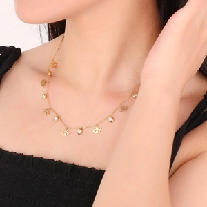Macro view of gold evil eye necklace with sparkling round charms on a female model