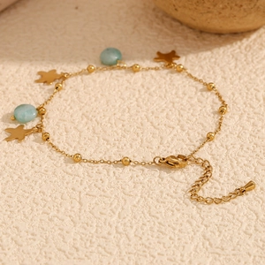 Detailed macro view of 18K gold star charms and green amazonite beads on a foot anklet