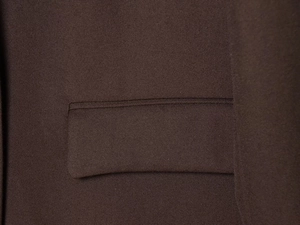 Detailed macro view of dark brown twill fabric texture and pocket flap craftsmanship