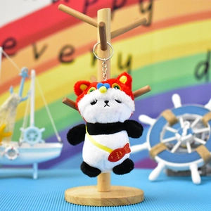 Close-up of cute plush panda keychain with festive red lion dance hat and fish bag