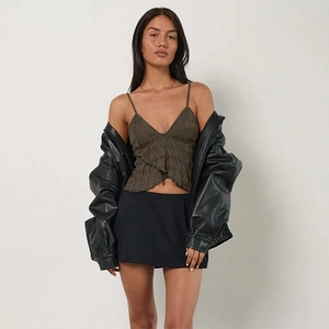 Detail shot of the deep green lace camisole paired with a black leather jacket