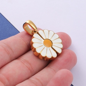 Macro shot of a handmade golden sunflower daisy charm with white petals and orange center