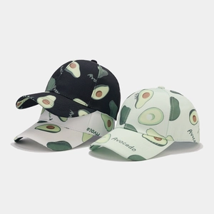 Detailed view of three avocado pattern baseball caps in black, white, and mint green