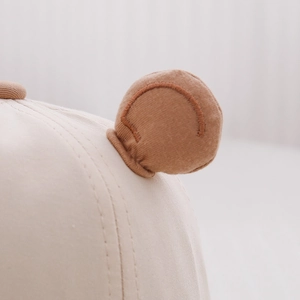 Close-up of baby hat with soft bear ears showing premium cotton knit fabric and stitching