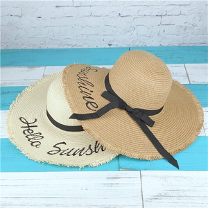 Close-up of wide brim straw hat with Hello Sunshine embroidery and frayed edges