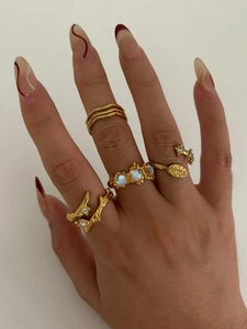 Detail of vintage gold stacked rings featuring moonstone and leaf design on hand