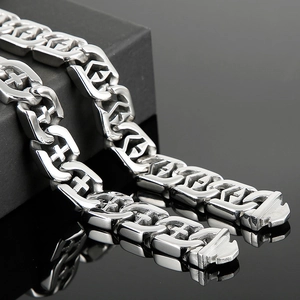 Detailed macro view of silver punk chain links with hollow cross patterns on black background