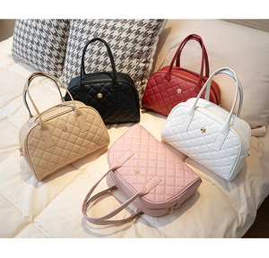 Cinq sacs à main matelassés de couleurs variées avec logo fleur sur un lit douillet