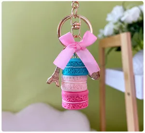 Nahaufnahme eines Macaron-Schlüsselanhängers mit rosa Schleife und Eiffelturm-Deko