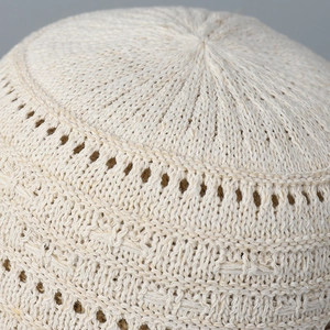 Close-up of the breathable hollow knit texture and intricate weave on the cream bucket hat