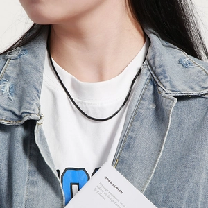 Close-up of a minimalist black square snake bone chain necklace worn by a model