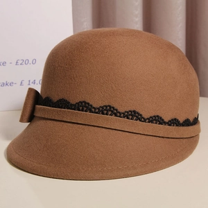 Detailed texture of caramel wool felt hat with black lace trim and ribbon bow accent