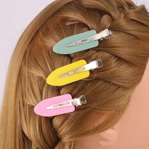 Three 6cm colorful seamless hair clips in pink, yellow, and mint green on blonde braided hair