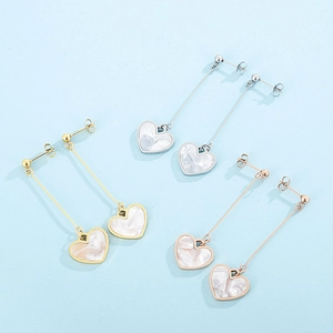 Detail of heart drop earrings in gold, silver and rose gold with marble texture inlay