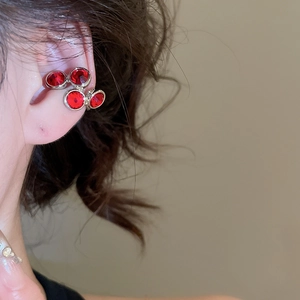 Close-up of silver ear cuff with four red zircons worn on model's upper ear