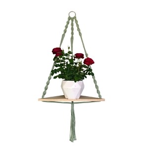 Green handmade macrame wall shelf with triangular wood board and tassel decor