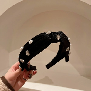 Detail of black velvet headband with snowflake pearls and sparkling rhinestones