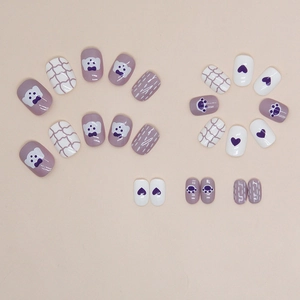 Purple and white press-on nail set featuring cute bear, heart, and grid designs
