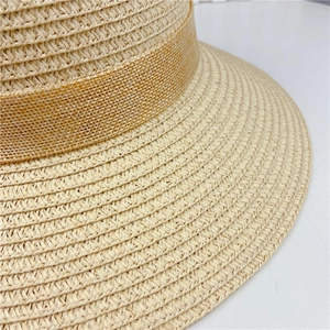 Close-up of the intricate straw weave texture and fabric ribbon on a sun hat