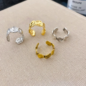Detailansicht von vier unregelmäßigen verstellbaren Ringen in Gold und Silber auf Stoff