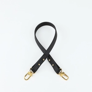 Close-up of black lychee grain leather shoulder strap with gold swivel metal hook clasp