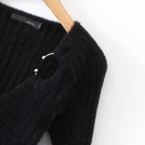Close-up of black V-neck knit top showing soft faux mink texture and silver metal shoulder rings