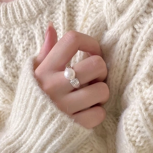 Elegant 925 sterling silver pearl ring with textured band shown on hand with sweater