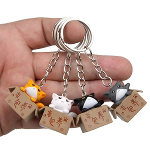 Close-up of cute 3D cartoon cats in miniature boxes with metal keychain rings