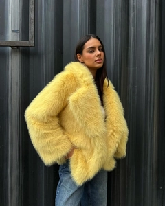 Close-up of bright yellow faux fur coat texture with stylish oversized lapel collar