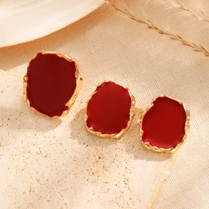 Detail of vintage irregular square jewelry set with red enamel and gold metal frames