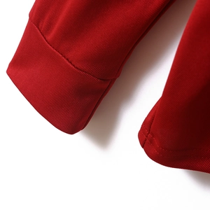 Detail of red long sleeve polo shirt showing the textured piqué fabric and ribbed cuff
