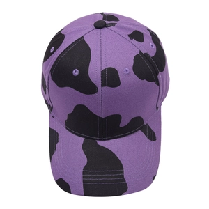 Detailed close-up of cow print pattern on a trendy purple baseball cap with curved brim