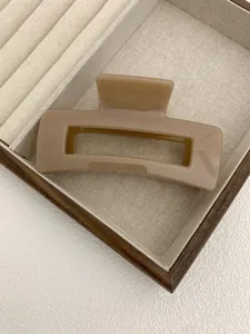 Close-up of minimalist milk tea brown square hair claw clip on jewelry display tray
