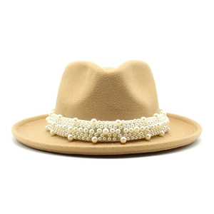 Detalle de sombrero de lana color camello con banda decorativa de elegantes perlas blancas
