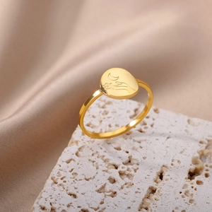 Detailed view of an 18K gold stainless steel ring with moon engraving on a stone base
