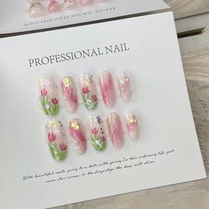 Faux ongles faits main avec tulipes roses, strass scintillants et perles élégantes