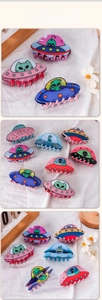 Detailed close-up of cartoon alien and UFO claw clips with durable metal springs