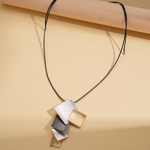 Detail of matte geometric diamond pendant necklace with textured metallic finish