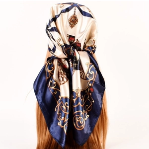 Detail of vintage horse carriage print silk scarf tied as a hair accessory on model