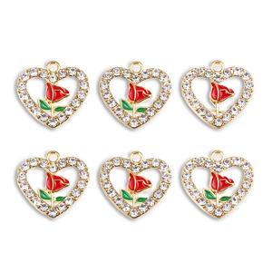 Detail view of heart-shaped red rose alloy pendants with glittering crystals on white background